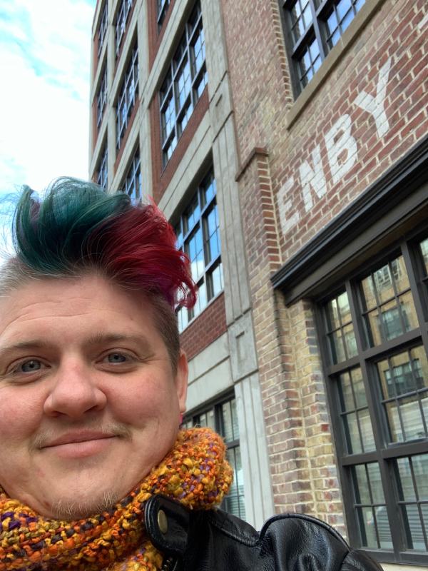 frances reed in front of building reading 'enby'